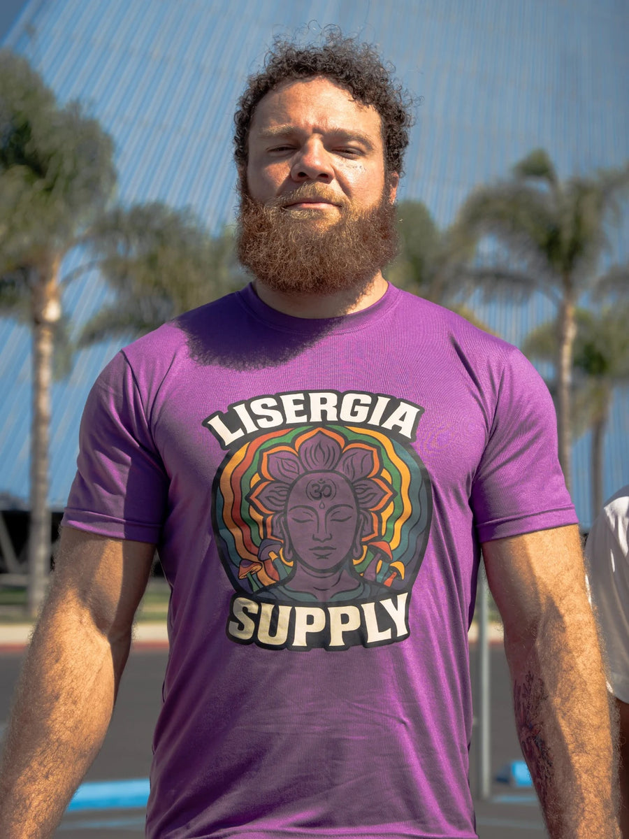 Camiseta roxa Logo Lisergia no corpo, com estampa colorida da marca, fotografada de frente ao ar livre.